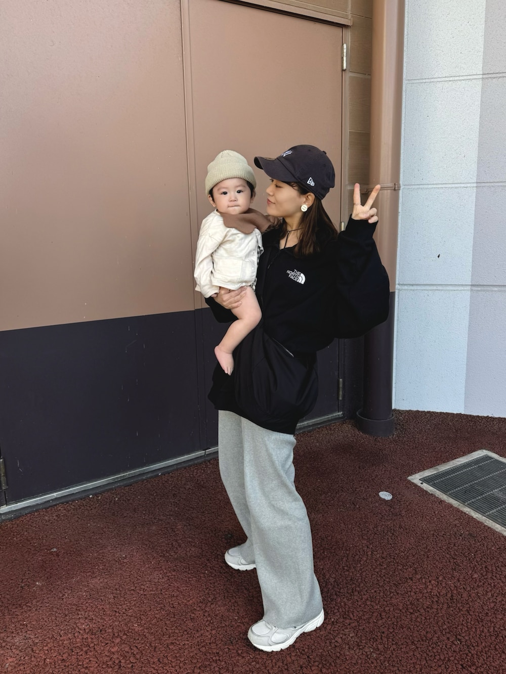 ブラック系のスウェット、グレー系のパンツ、ブラック系のショルダーバッグを着用したレディースの秋コーディネートの4枚目の写真