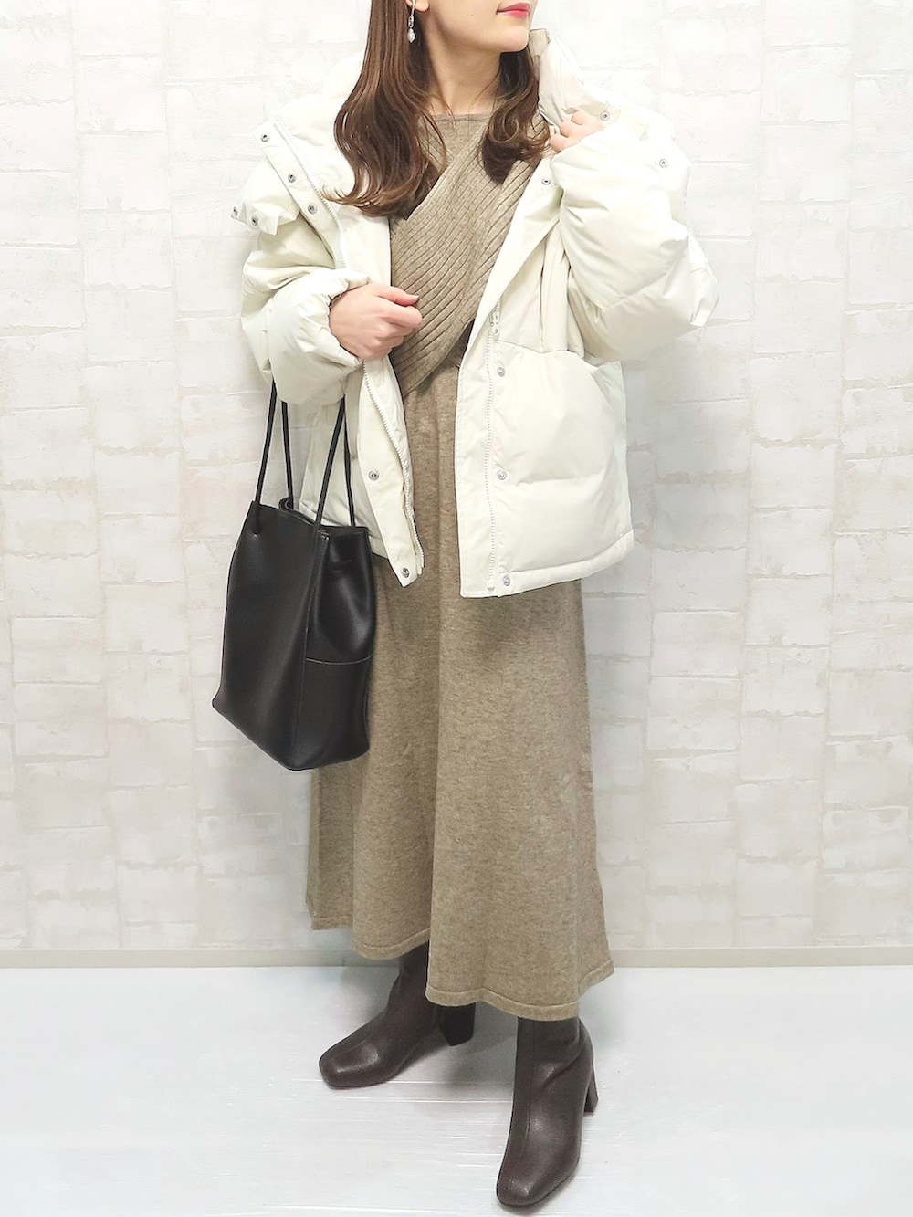 ベージュ系のダウンジャケット/コート、ベージュ系のワンピース、ブラウン系のブーツを着用したレディースの冬コーディネートの3枚目の写真
