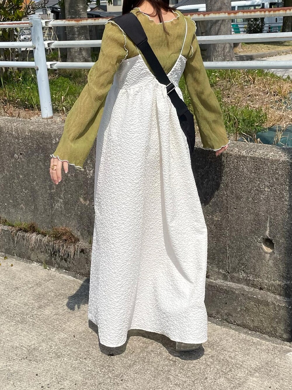 ホワイト系のワンピース、グリーン系のTシャツ/カットソー、ブラック系のショルダーバッグを着用したレディースの春コーディネートの5枚目の写真