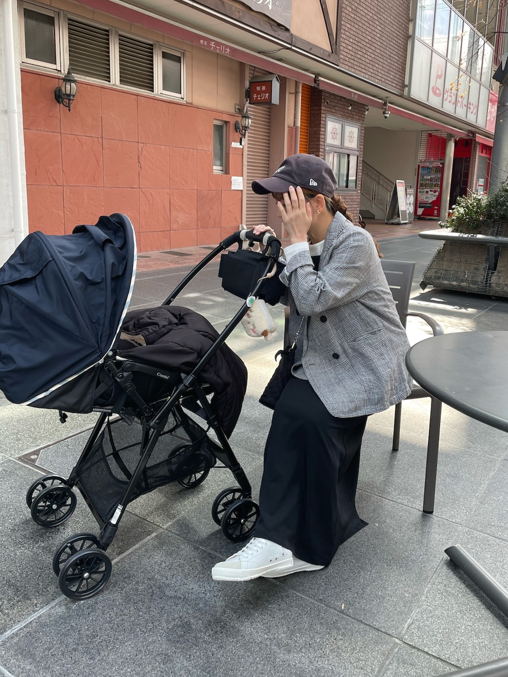 ブラック系のテーラードジャケット、ブラック系のワンピース、ブラック系のショルダーバッグを着用したレディースの春コーディネートの2枚目の写真