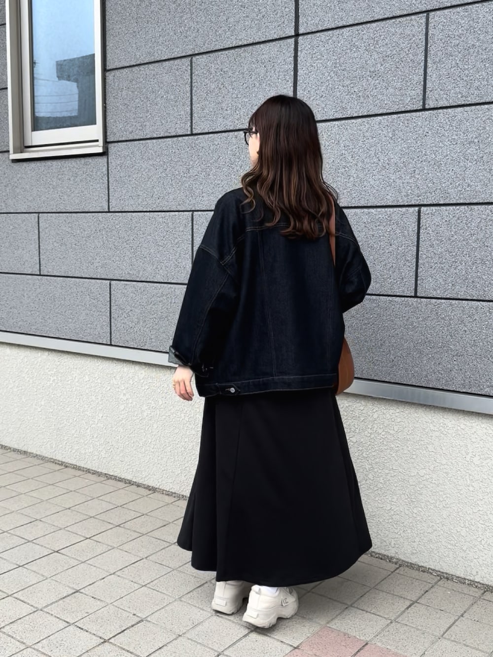 ブラック系のワンピース、ブラウン系のショルダーバッグ、ブルー系のデニムジャケットを着用したレディースの春コーディネートの4枚目の写真