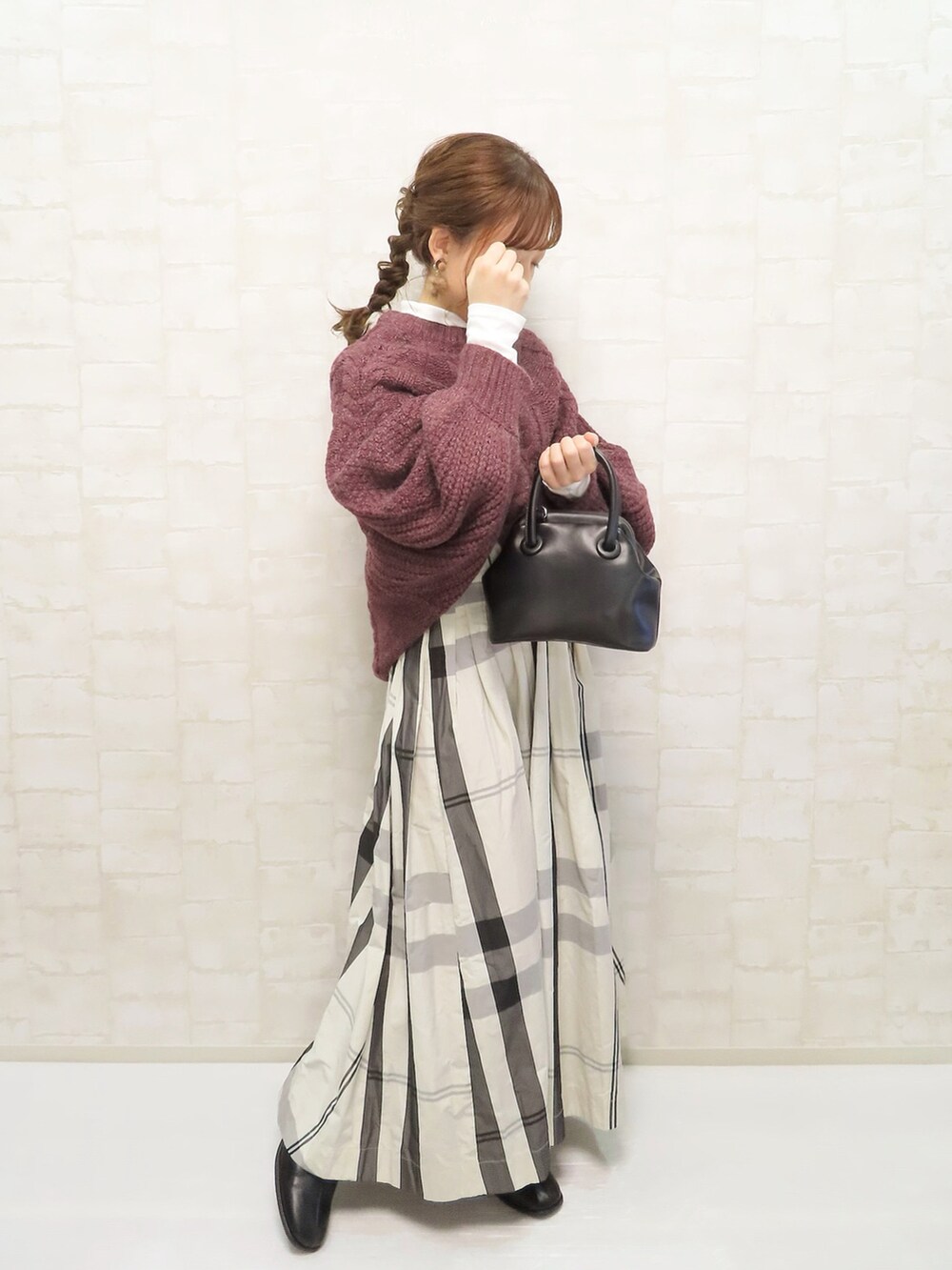 ホワイト系のスカート、パープル系のニット/セーター、ホワイト系のTシャツ/カットソーを着用したレディースの冬コーディネートの2枚目の写真