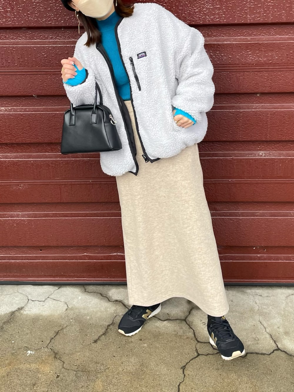 ベージュ系のブルゾン、ブルー系のニット/セーター、ベージュ系のスカートを着用したレディースの冬コーディネートの5枚目の写真