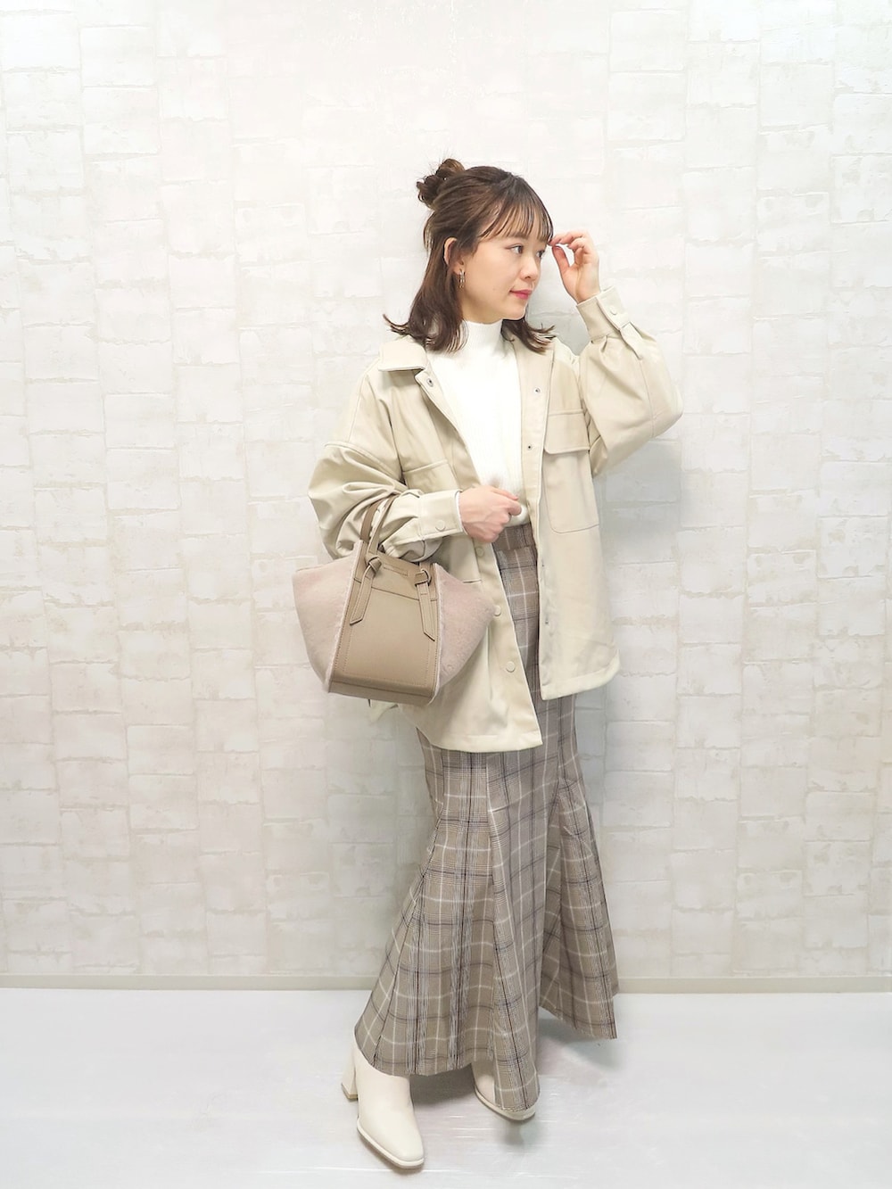 ホワイト系のその他アウター、ホワイト系のニット/セーター、ブラウン系のスカートを着用したレディースの冬コーディネートの4枚目の写真