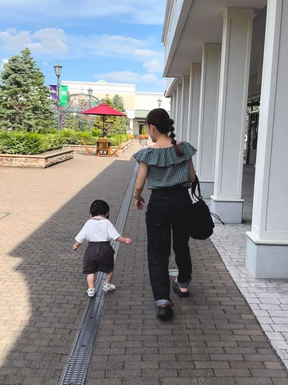 ブラック系のサンダル、グリーン系のトップス、ブラック系のパンツを着用したレディースの夏コーディネートの4枚目の写真