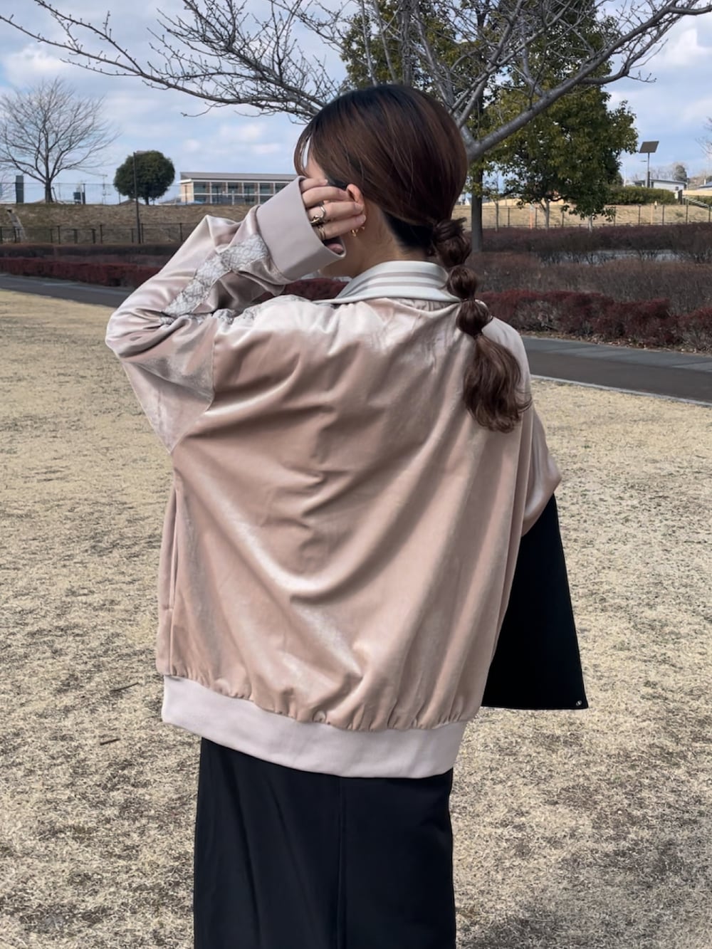 ベージュ系のスウェット、ブラック系のワンピース、ホワイト系のスニーカーを着用したレディースの春コーディネートの2枚目の写真