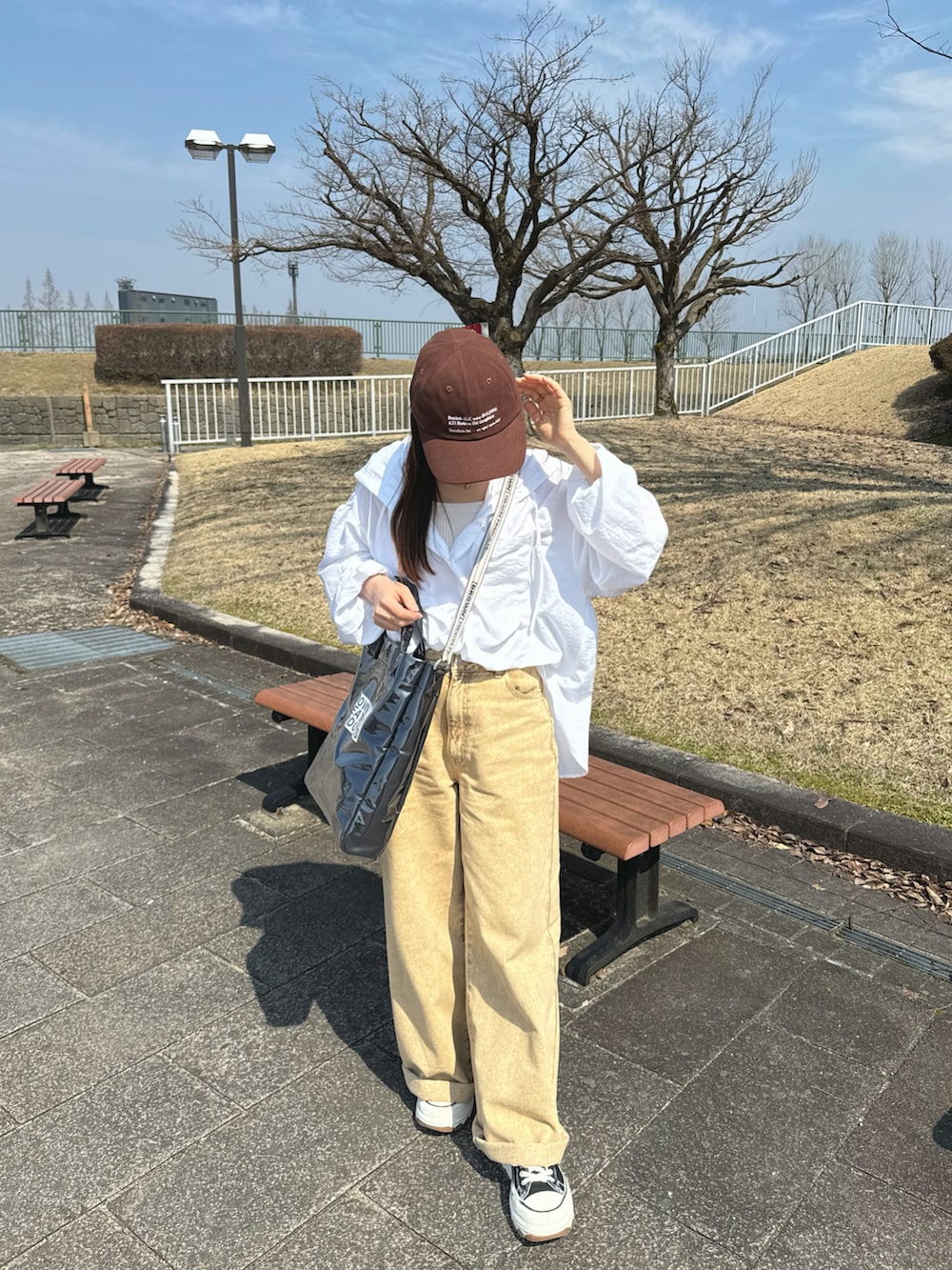 ホワイト系のシャツ/ブラウス、ブラック系のトートバッグ、ベージュ系のパンツを着用したレディースの春コーディネートの4枚目の写真