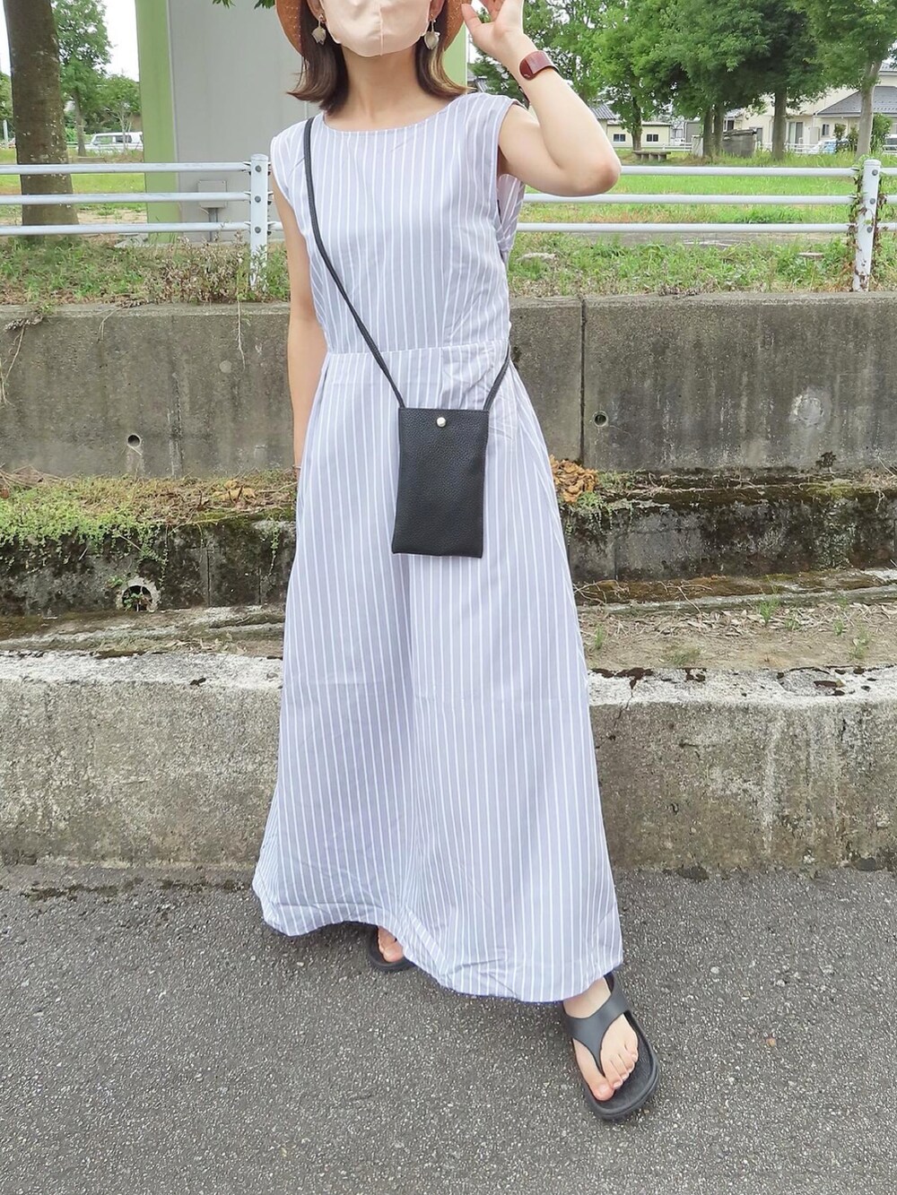 グレー系のワンピース、ブラック系のショルダーバッグ、ブラック系のサンダルを着用したレディースの夏コーディネートの5枚目の写真