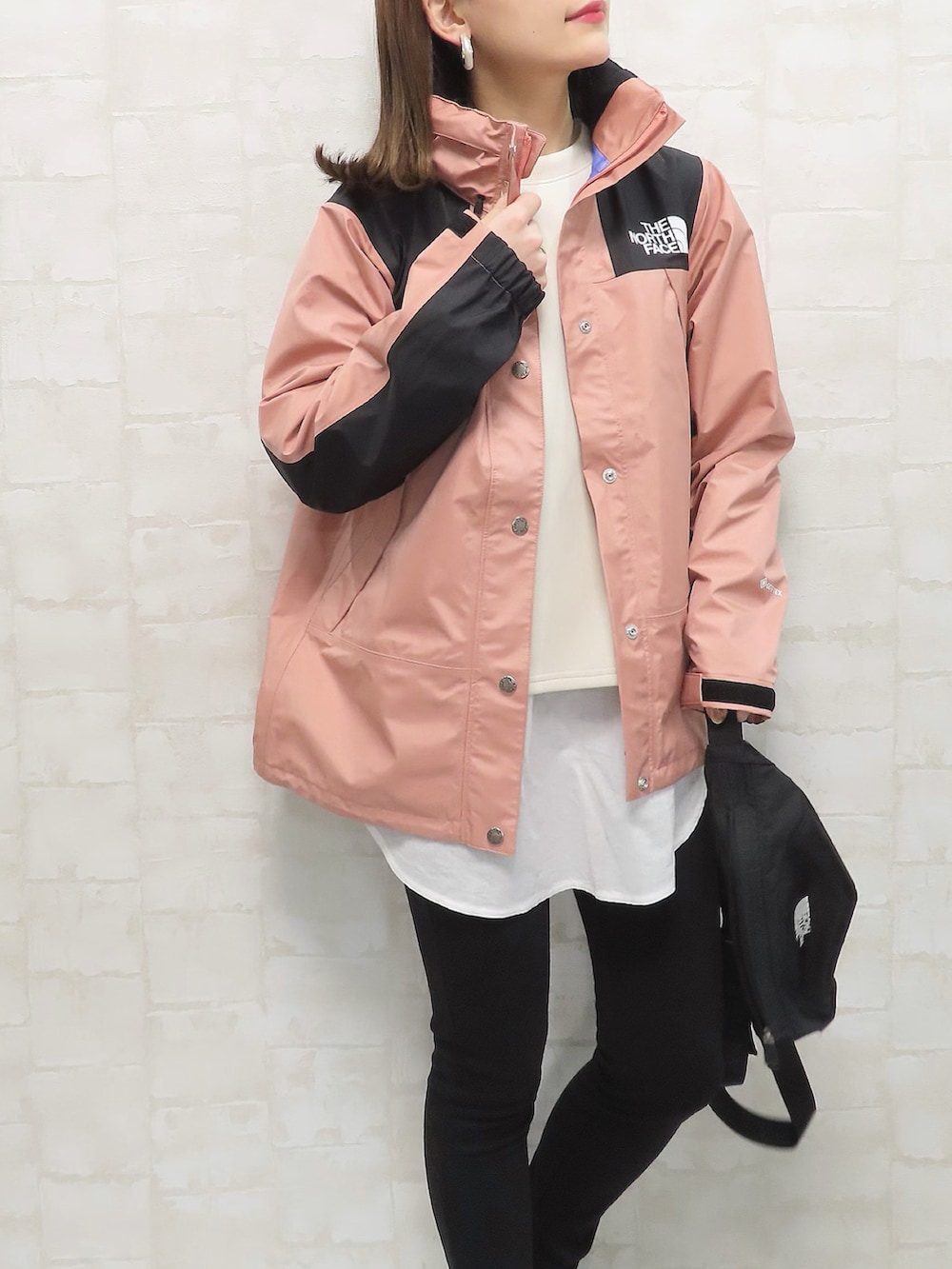 ピンク系のマウンテンパーカー、ホワイト系のTシャツ/カットソー、ホワイト系のスカートを着用したレディースの春コーディネートの5枚目の写真