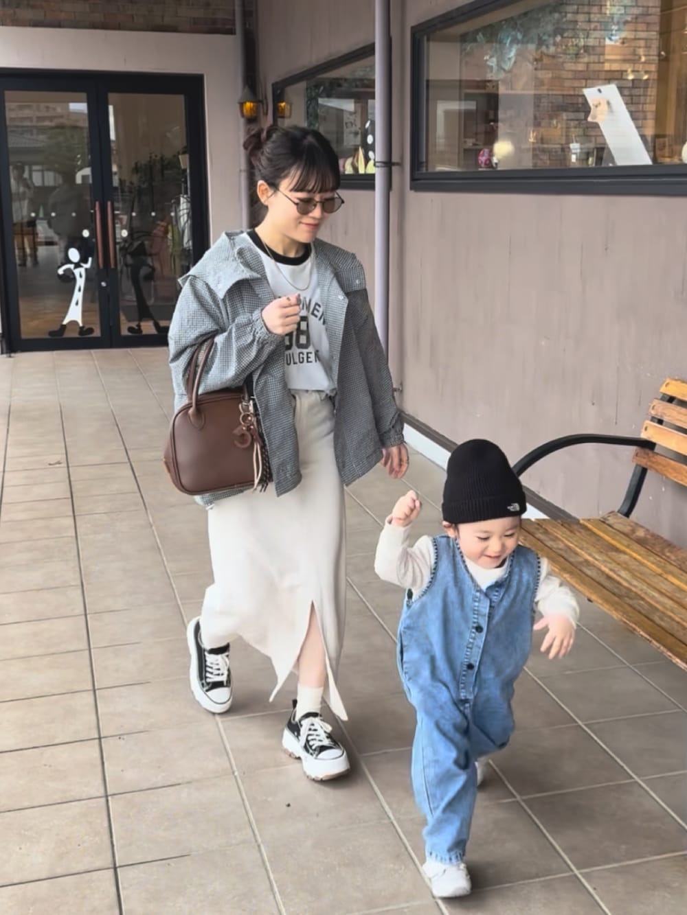 グレー系のブルゾン、ブラウン系のショルダーバッグ、ホワイト系のTシャツ/カットソーを着用したレディースの春コーディネートの4枚目の写真