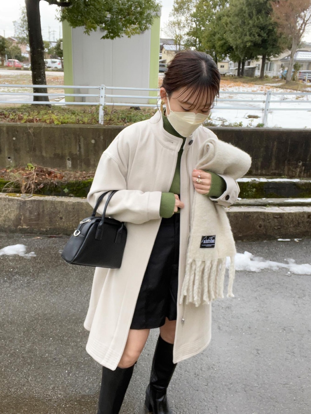 ホワイト系のその他アウター、グリーン系のニット/セーター、ブラック系のボストンバッグを着用したレディースの冬コーディネートの5枚目の写真