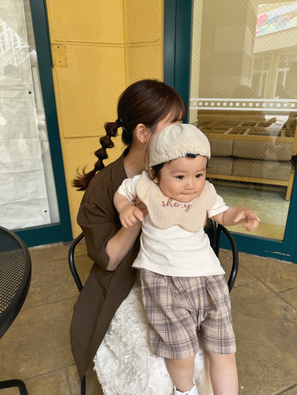 ブラウン系のテーラードジャケット、ブラック系のトートバッグ、ホワイト系のワンピース/ドレスを着用したレディースの夏コーディネートの2枚目の写真