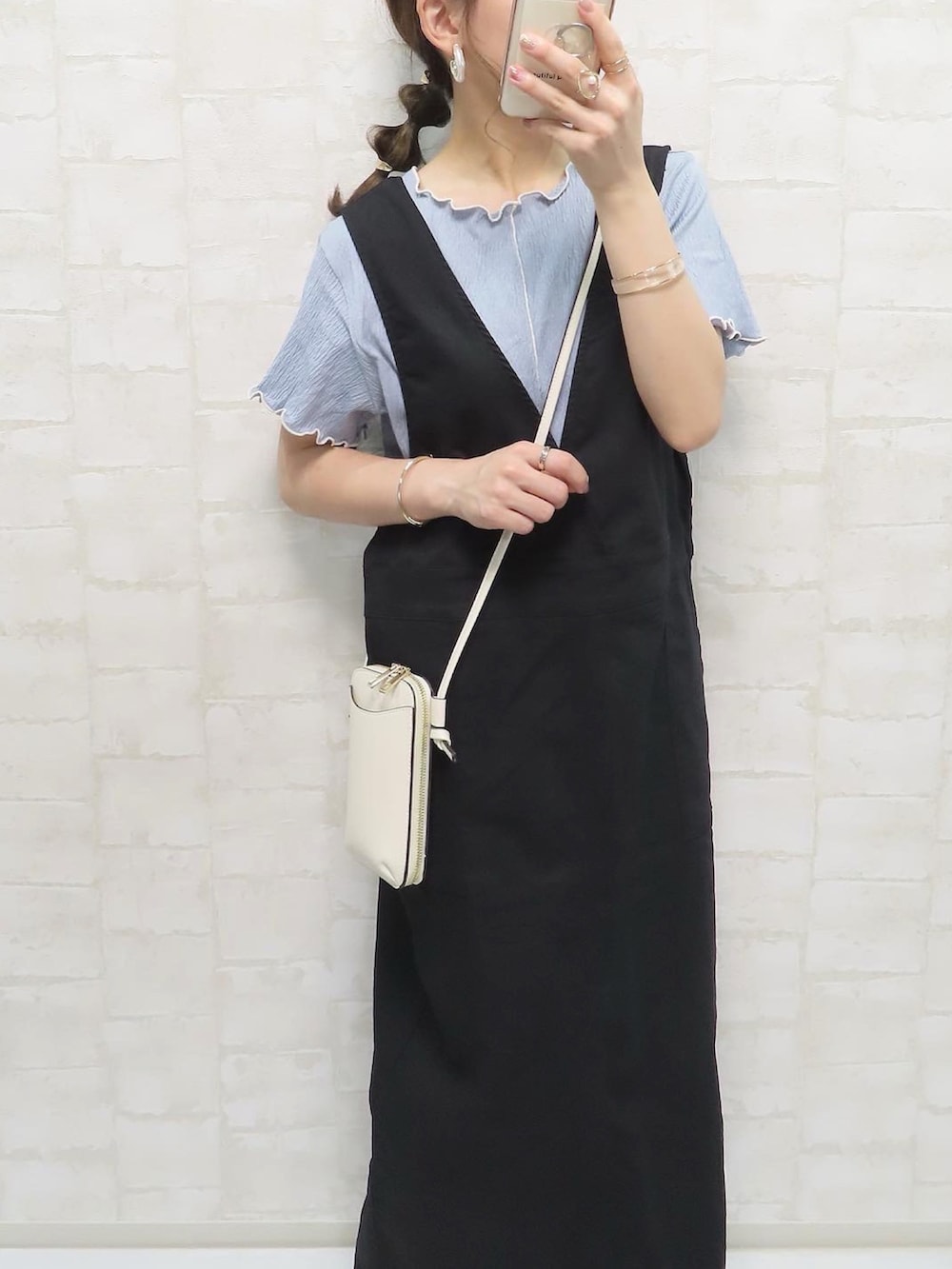 ブルー系のTシャツ/カットソー、ブラック系のジャンパースカート、ベージュ系のサンダルを着用したレディースの夏コーディネートの3枚目の写真