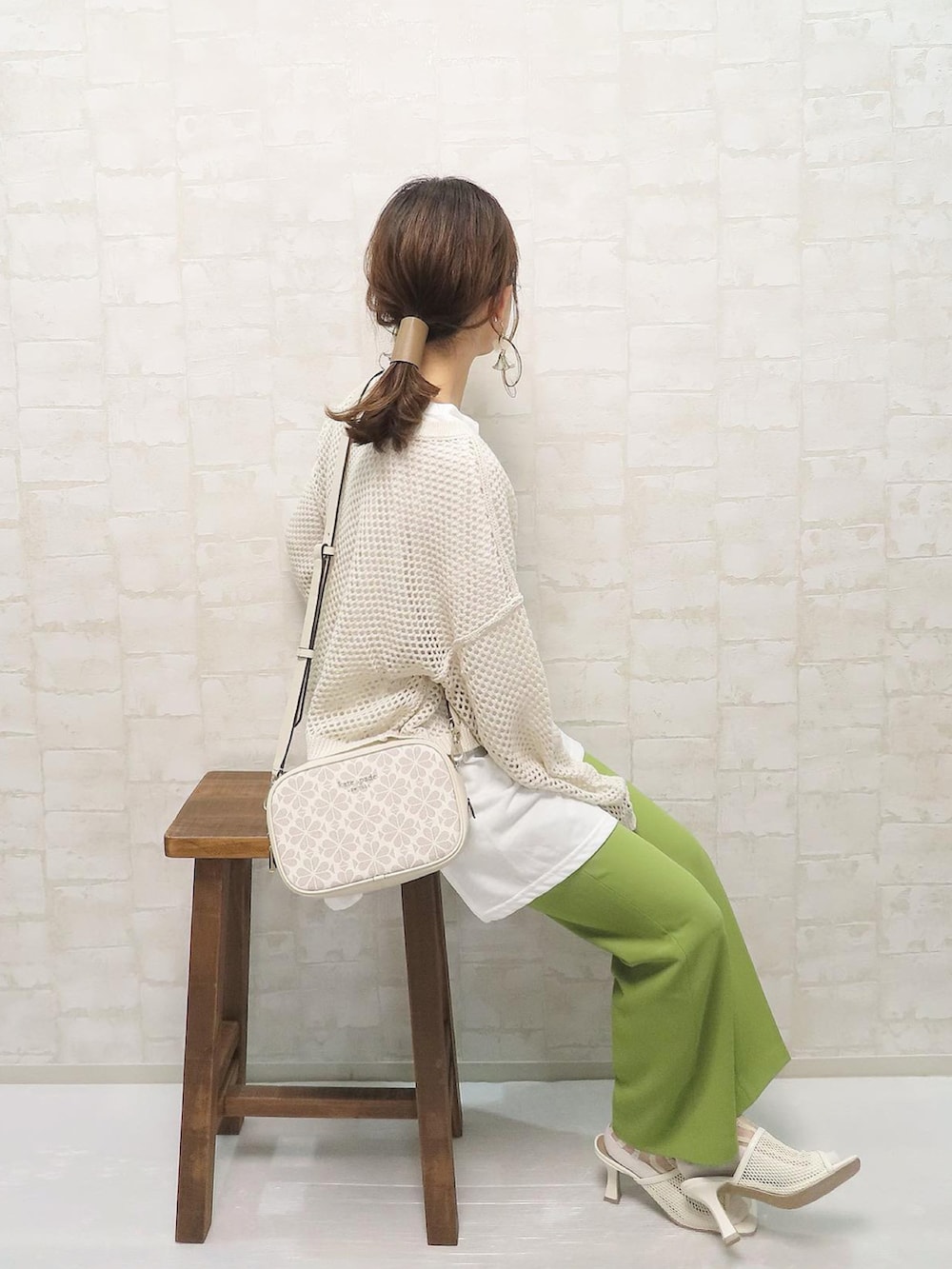 ホワイト系のアンサンブル、グリーン系のその他パンツ、ホワイト系のショルダーバッグを着用したレディースの春コーディネートの2枚目の写真
