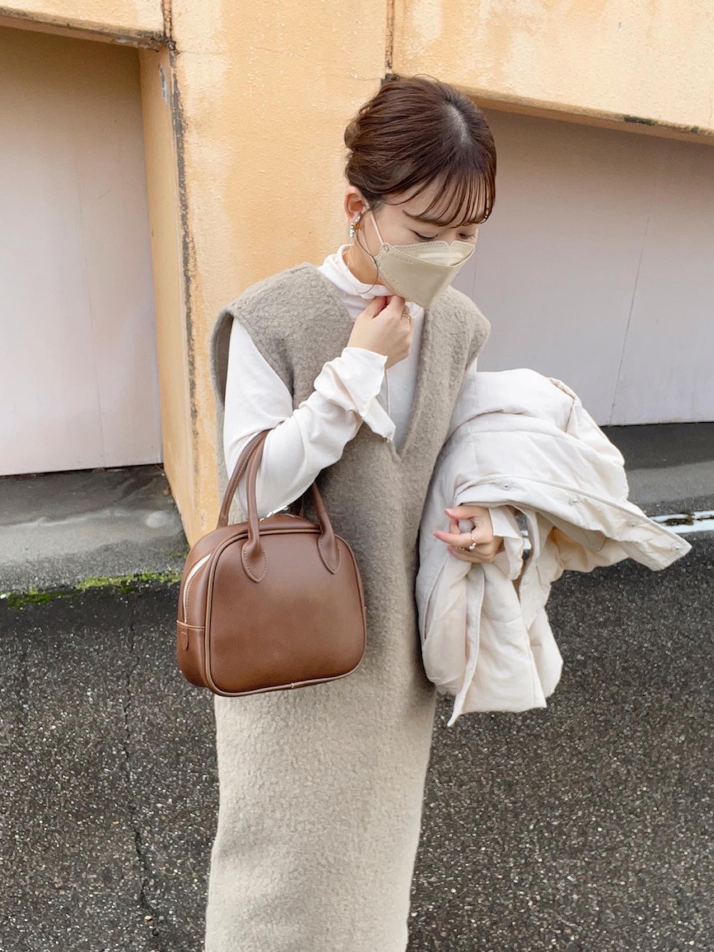 ホワイト系のTシャツ/カットソー、ブラウン系のワンピース、ホワイト系のダウンジャケット/コートを着用したレディースの冬コーディネートの2枚目の写真