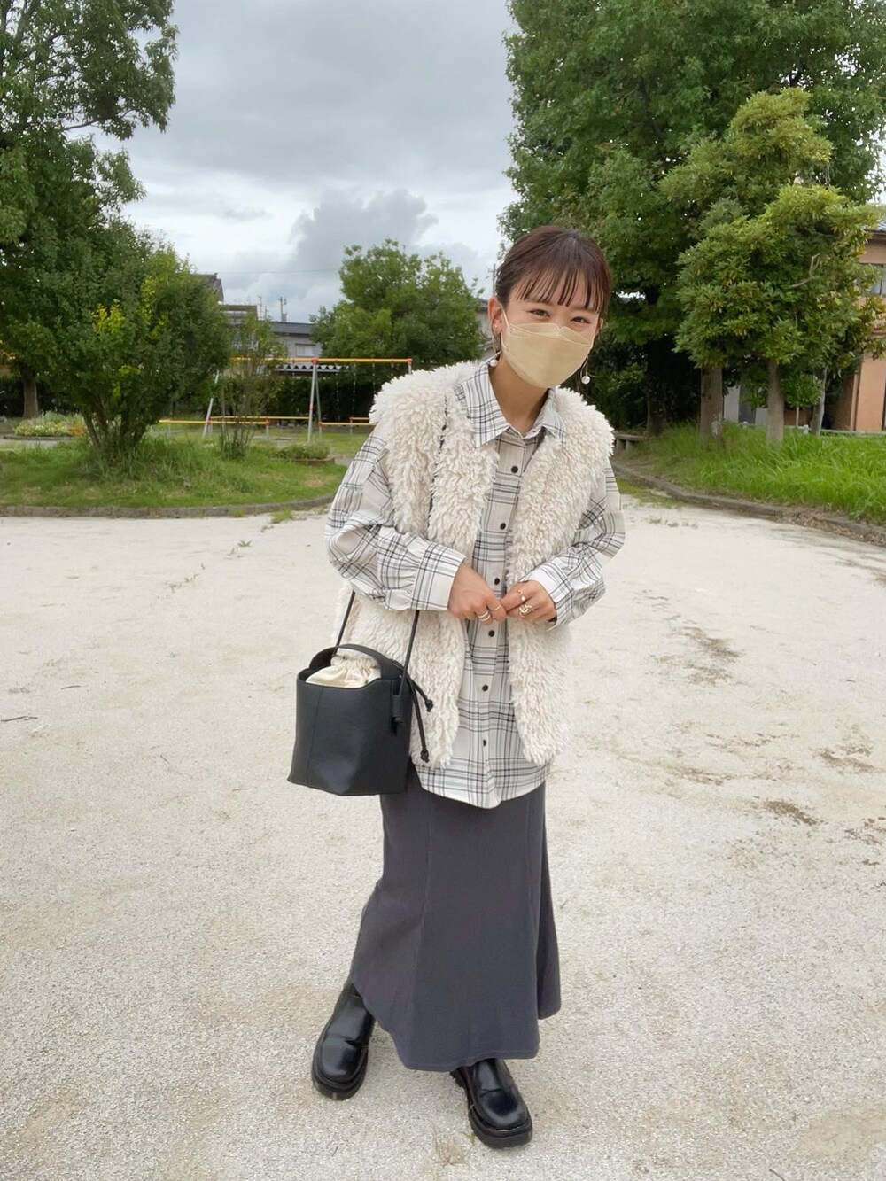 ホワイト系のベスト、ホワイト系のシャツ/ブラウス、グレー系のスカートを着用したレディースの秋コーディネートの2枚目の写真