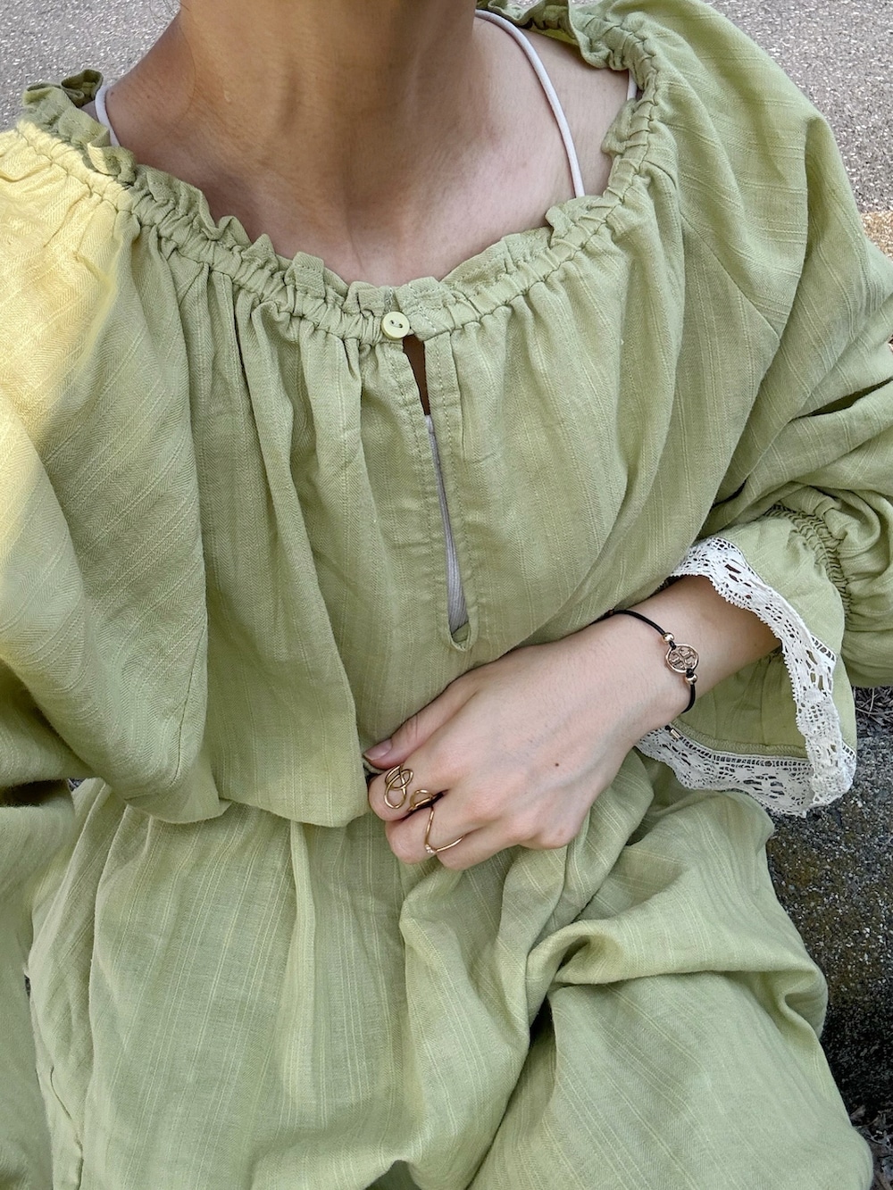 グリーン系のワンピース、ホワイト系のスニーカー、ブルー系のデニムパンツを着用したレディースの夏コーディネートの5枚目の写真