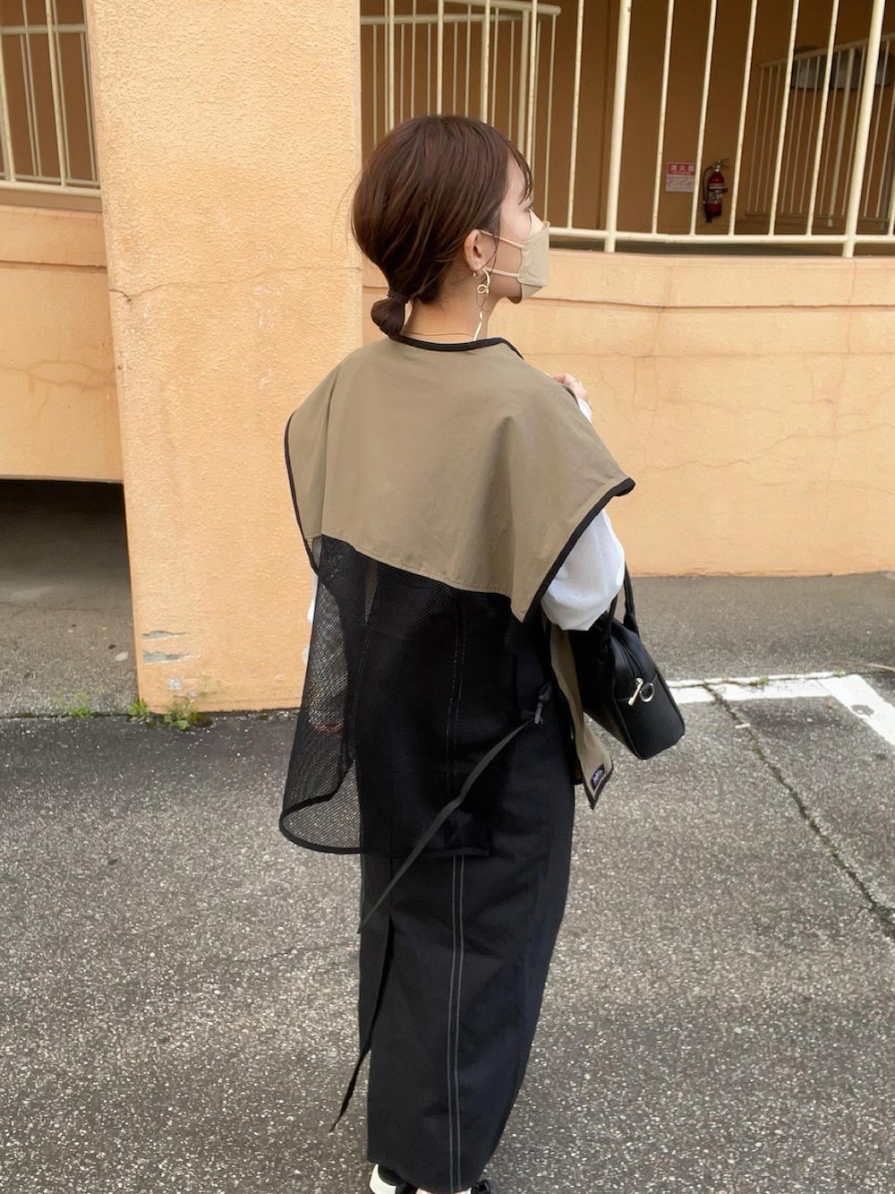 グリーン系のベスト、ブラック系のワンピース/ドレス、ホワイト系のTシャツ/カットソーを着用したレディースの春コーディネートの4枚目の写真