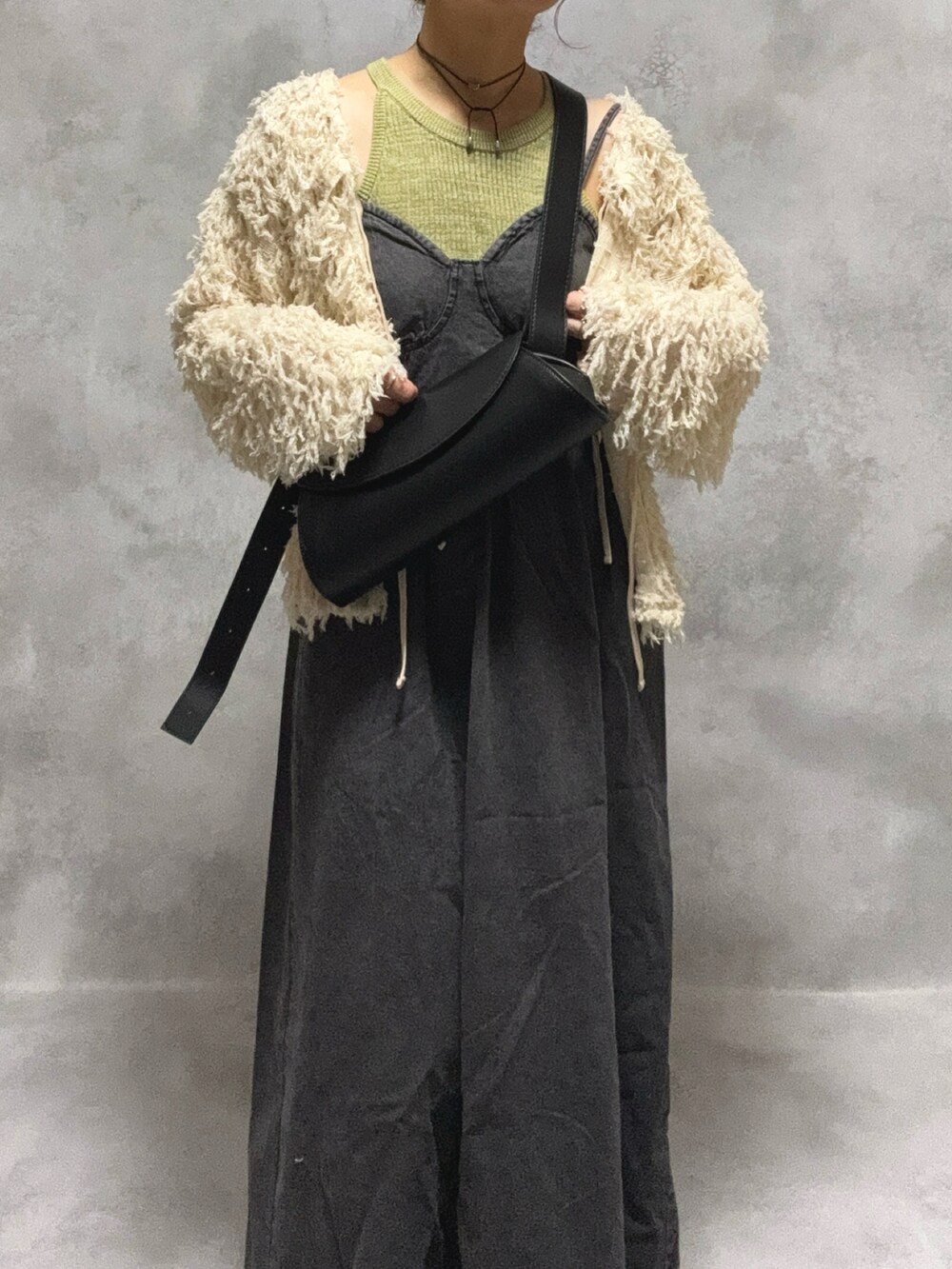 グリーン系のタンクトップ、ブラック系のワンピース/ドレス、ホワイト系のカーディガン/ボレロを着用したレディースの秋コーディネートの3枚目の写真