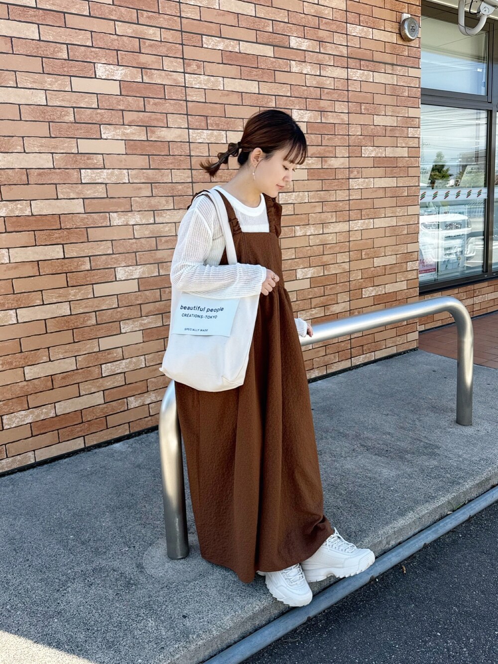 ブラウン系のワンピース、ホワイト系のトップス、ホワイト系のトートバッグを着用したレディースの春コーディネートの4枚目の写真