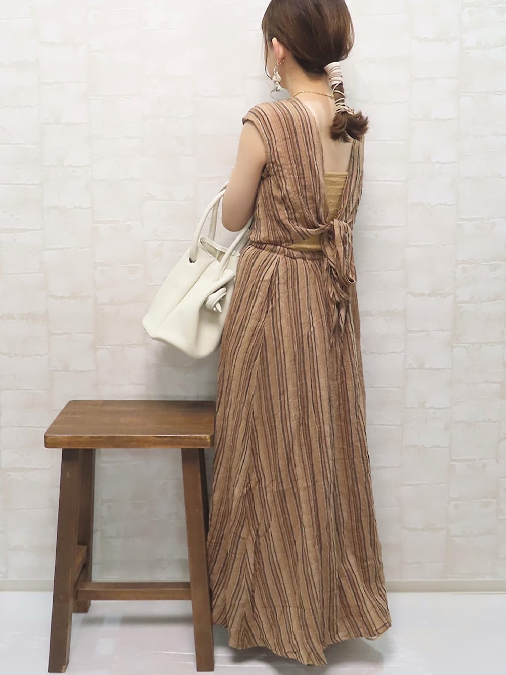 ブラウン系のワンピース、ホワイト系のニット/セーター、ホワイト系のハンドバッグを着用したレディースの春コーディネートの4枚目の写真