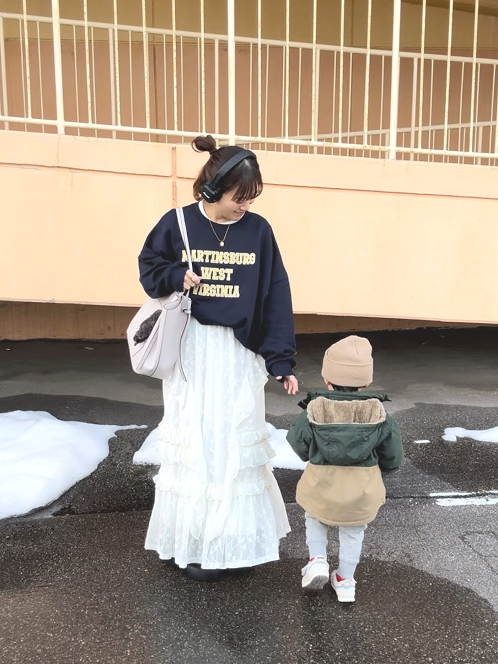 ホワイト系のスカート、ブルー系のスウェット、ホワイト系のバッグを着用したレディースの春コーディネートの2枚目の写真