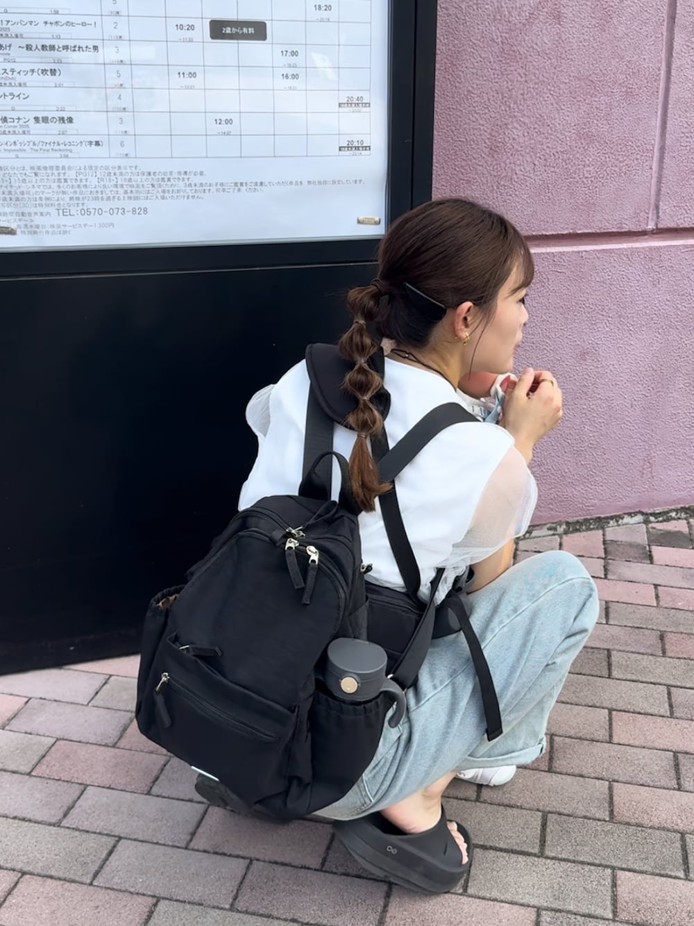 ホワイト系のトップス、ブルー系のデニムパンツ、ブラック系のサンダルを着用したレディースの夏コーディネートの4枚目の写真