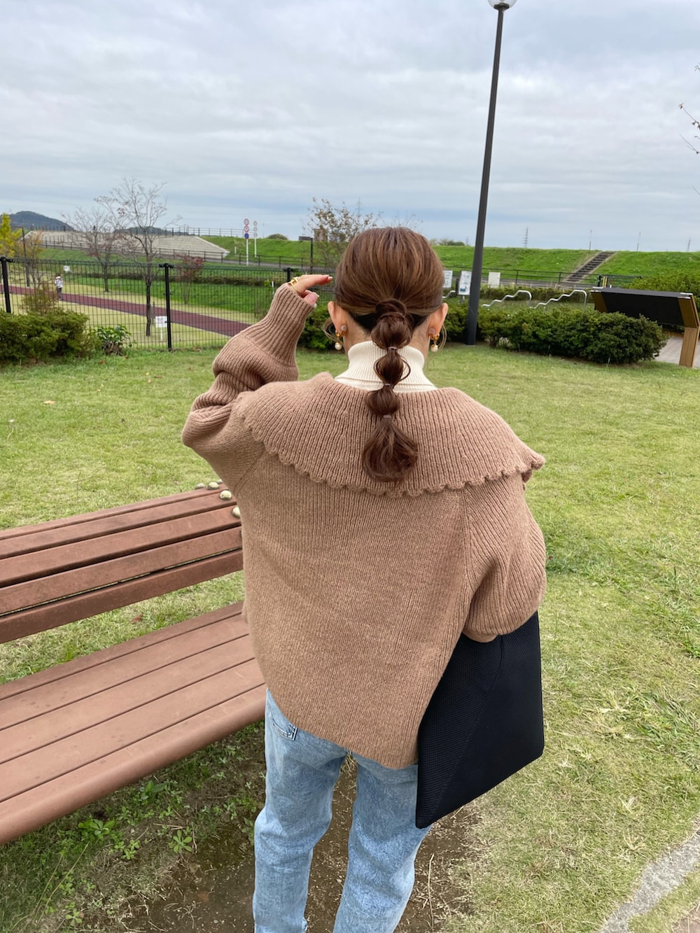 ブラウン系のニット/セーター、ホワイト系のニット/セーター、ブルー系のデニムパンツを着用したレディースの秋コーディネートの2枚目の写真