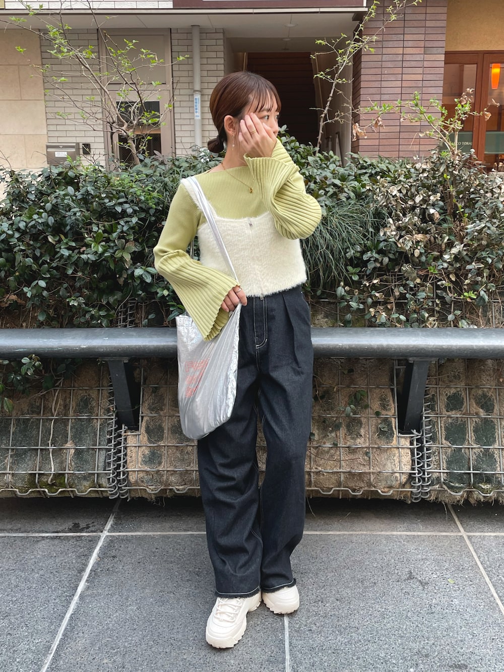 グリーン系のニット/セーター、ホワイト系のベスト、ブラック系のデニムパンツを着用したレディースの春コーディネートの3枚目の写真