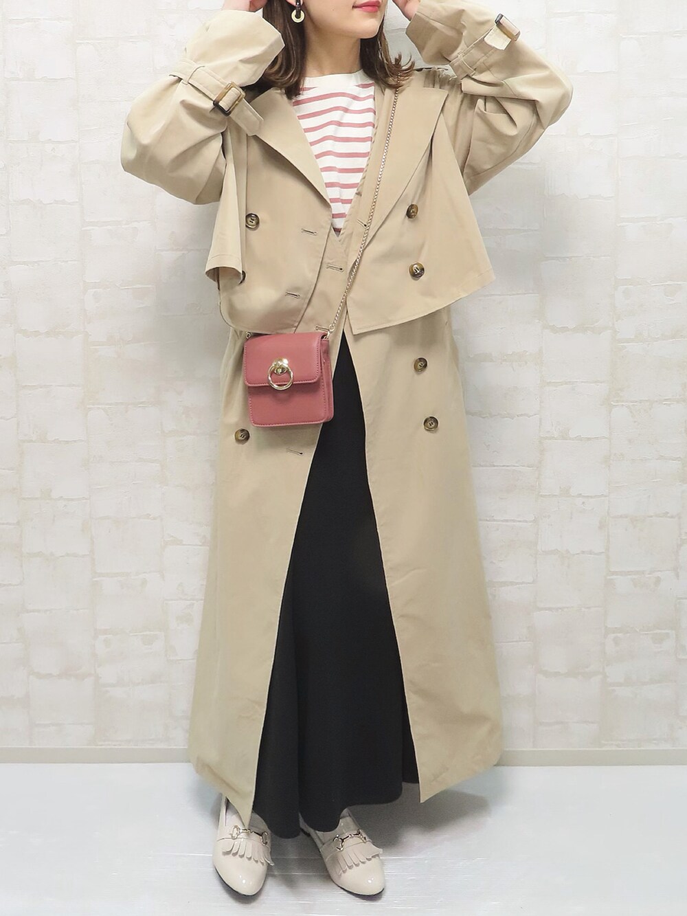 ベージュ系のトレンチコート、ピンク系のトップス、ピンク系のショルダーバッグを着用したレディースの春コーディネートの3枚目の写真