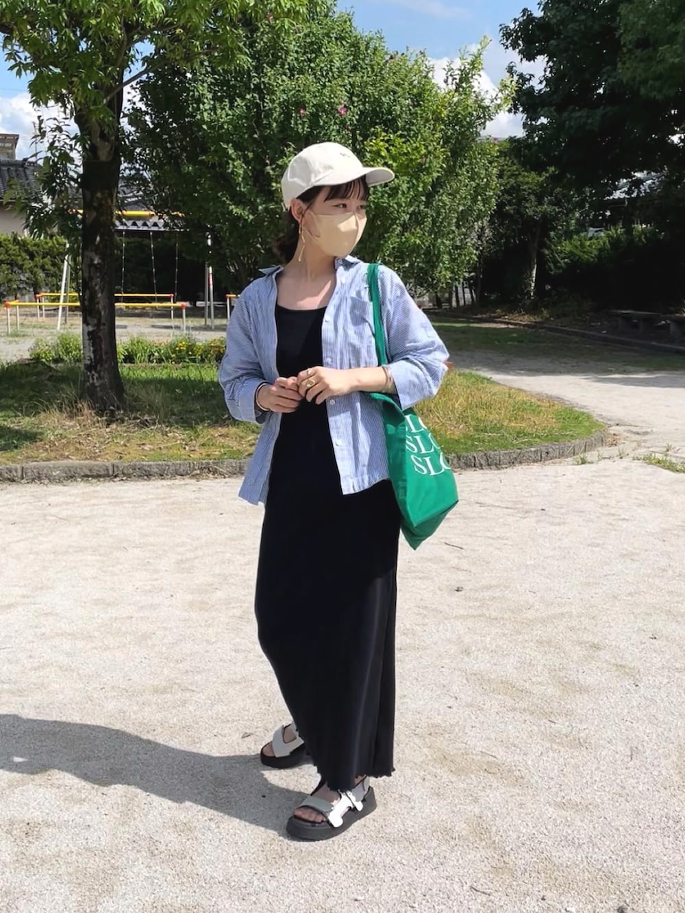 ブラック系のワンピース、ブルー系のシャツ/ブラウス、グリーン系のトートバッグを着用したレディースの夏コーディネートの2枚目の写真