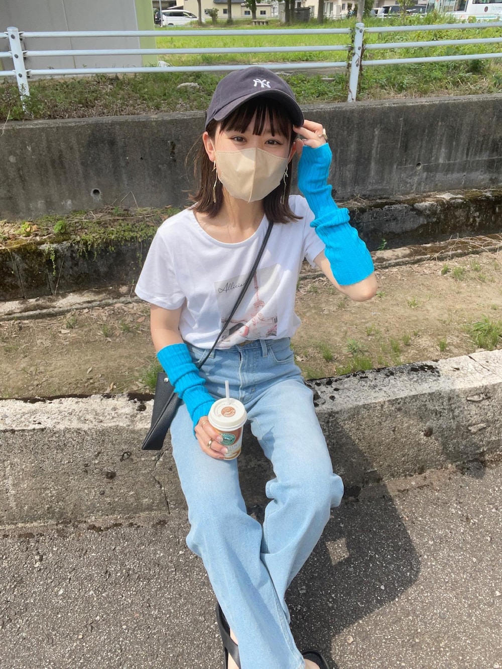 ブルー系のデニムパンツ、ホワイト系のTシャツ/カットソー、ブラック系のショルダーバッグを着用したレディースの夏コーディネートの3枚目の写真