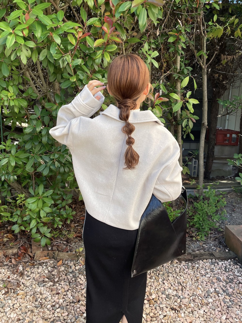 ホワイト系のブルゾン、ブラック系のバッグ、ホワイト系のスニーカーを着用したレディースの秋コーディネートの2枚目の写真