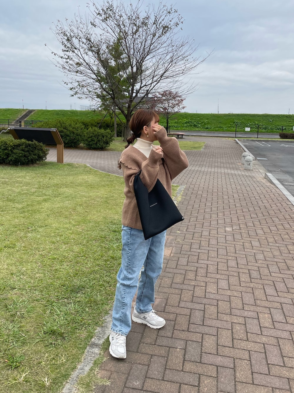 ブラウン系のニット/セーター、ホワイト系のニット/セーター、ブルー系のデニムパンツを着用したレディースの秋コーディネートの3枚目の写真