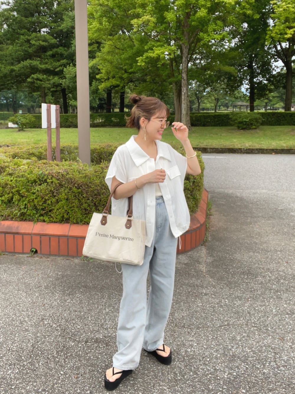 ホワイト系のシャツ/ブラウス、ブルー系のデニムパンツ、ホワイト系のトートバッグを着用したレディースの夏コーディネートの2枚目の写真