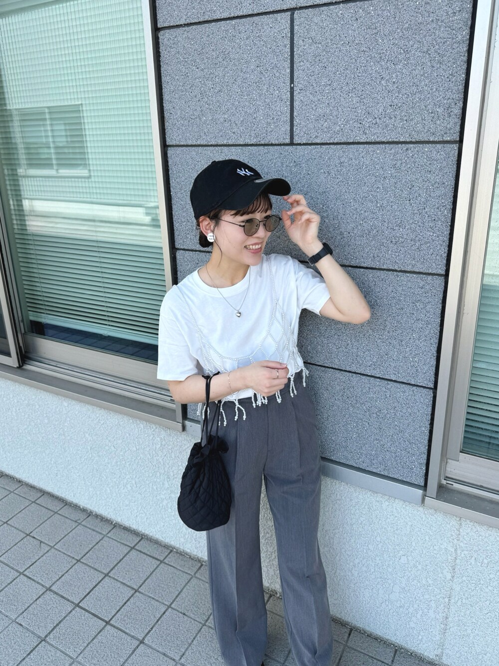 ホワイト系のベスト、ブラック系のサンダル、ホワイト系のTシャツ/カットソーを着用したレディースの夏コーディネートの2枚目の写真