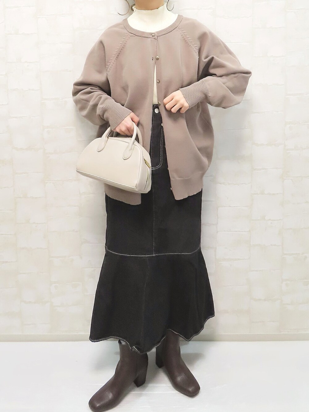 ベージュ系のカーディガン/ボレロ、ブラック系のスカート、ベージュ系のショルダーバッグを着用したレディースの冬コーディネートの3枚目の写真