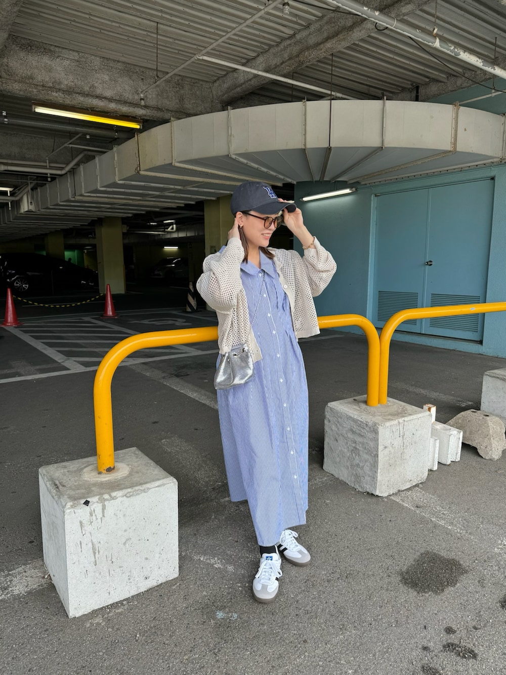 ブルー系のワンピース、ホワイト系のカーディガン/ボレロ、シルバー系のバッグを着用したレディースの春コーディネートの4枚目の写真