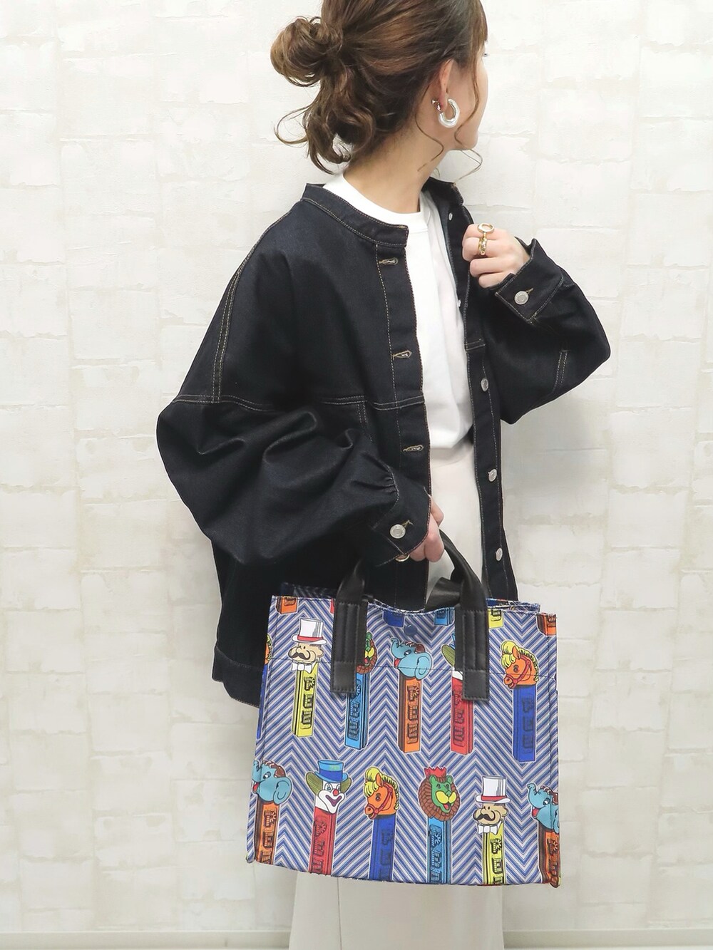 ブルー系のトートバッグ、ブルー系のデニムジャケット、ホワイト系のスカートを着用したレディースの春コーディネートの2枚目の写真
