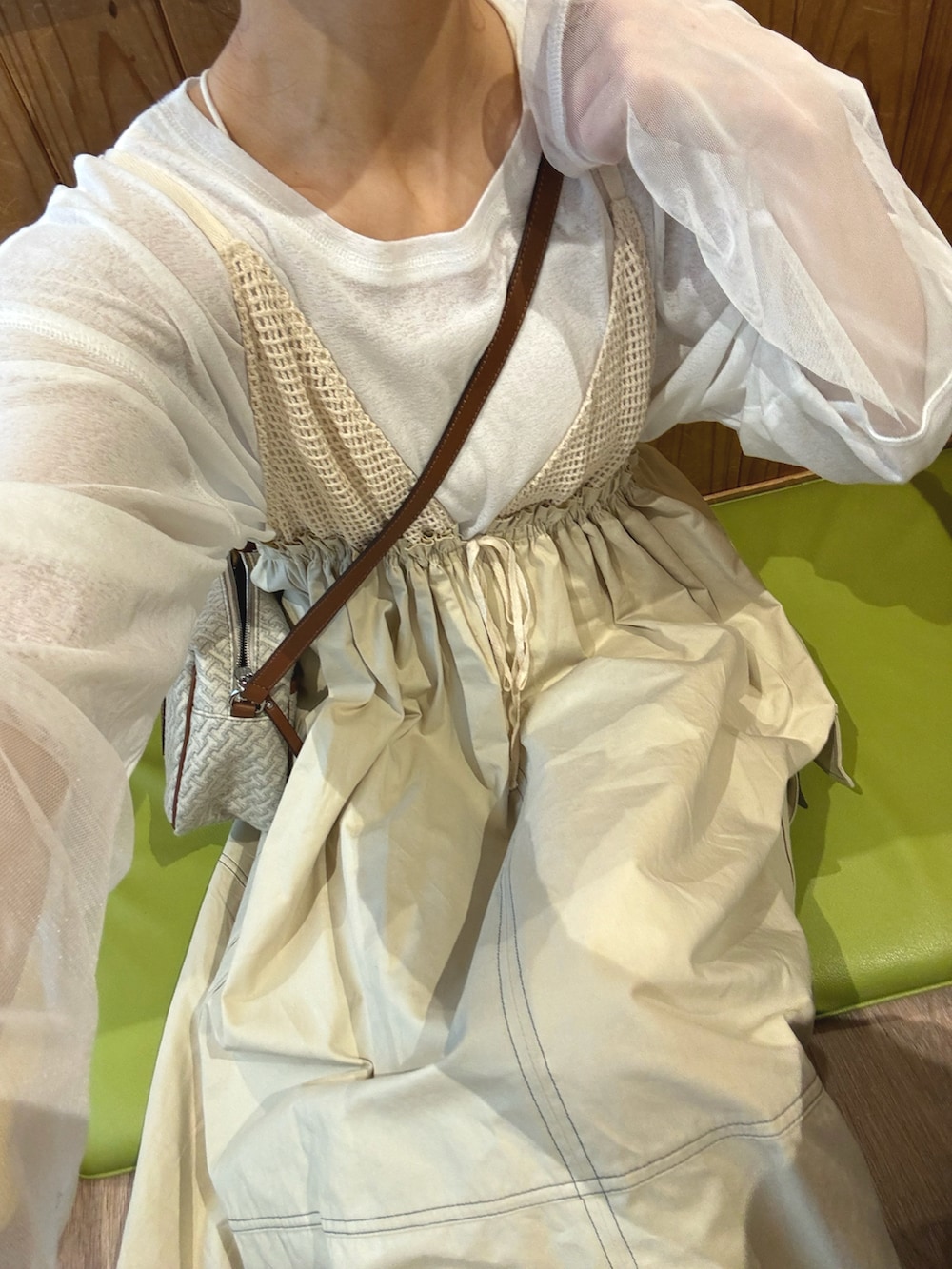 ベージュ系のワンピース、ブルー系のデニムジャケット、ホワイト系のショルダーバッグを着用したレディースの春コーディネートの2枚目の写真