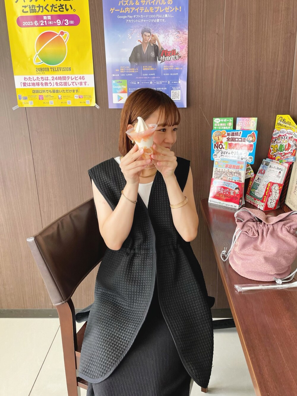 ブラック系のベスト、ホワイト系のタンクトップ、ピンク系のショルダーバッグを着用したレディースの夏コーディネートの3枚目の写真