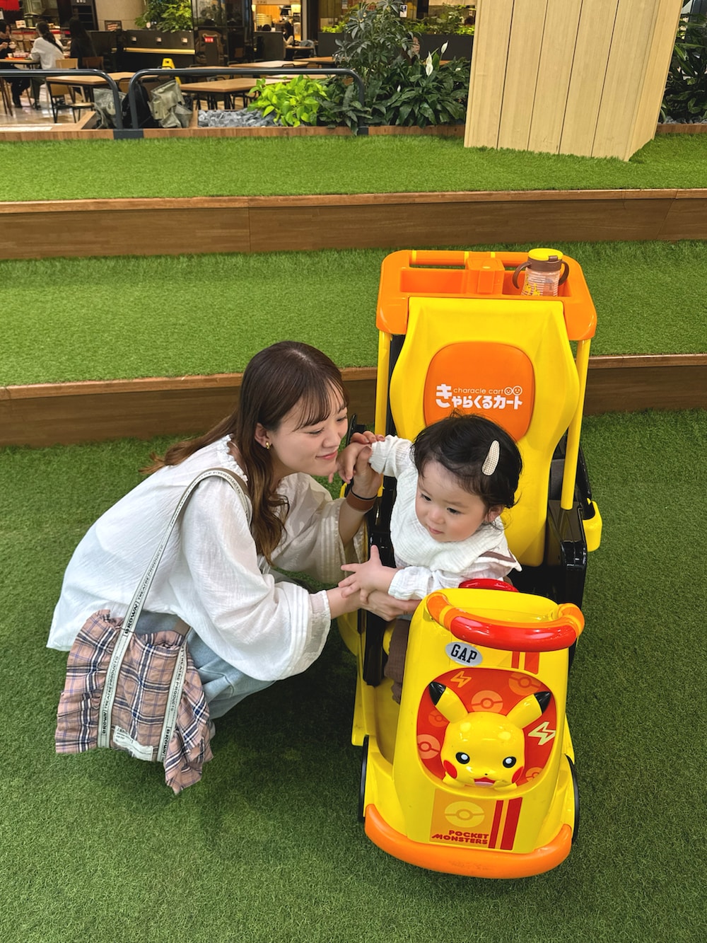 ホワイト系のトップス、ブルー系のデニムパンツ、ピンク系のトートバッグを着用したレディースの春コーディネートの2枚目の写真