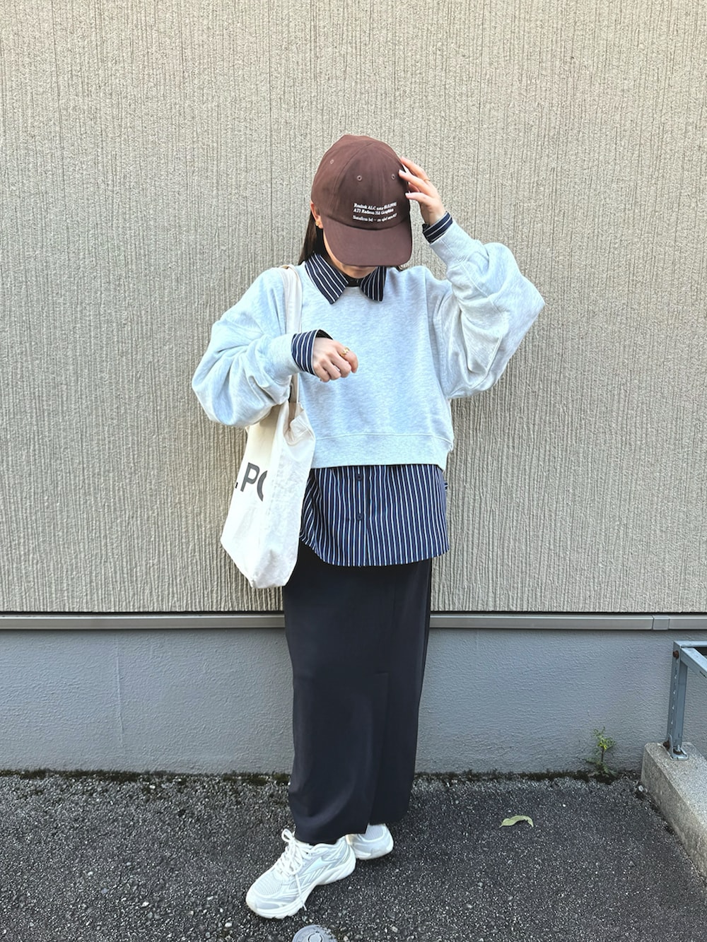 ブルー系のシャツ/ブラウス、ブラック系のスカート、ベージュ系のスニーカーを着用したレディースの春コーディネートの4枚目の写真