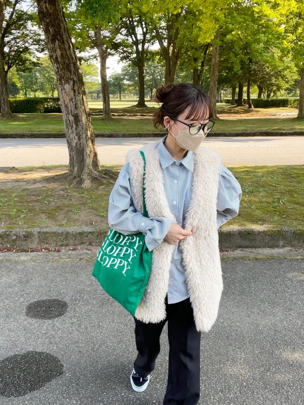 ブラック系のシャツ/ブラウス、ホワイト系のベスト、グリーン系のトートバッグを着用したレディースの秋コーディネートの2枚目の写真