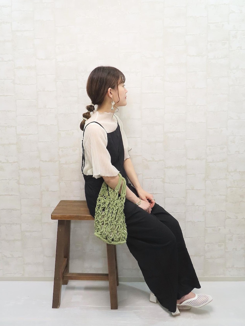 ホワイト系のTシャツ/カットソー、ブラック系のサロペット/オーバーオール、グリーン系のハンドバッグを着用したレディースの春コーディネートの2枚目の写真