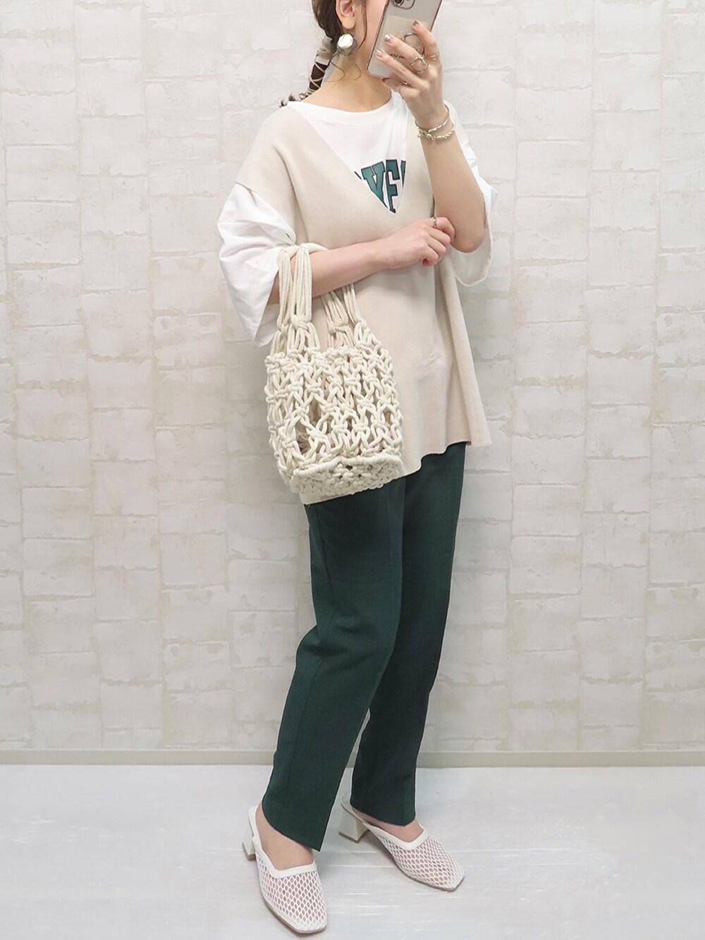 グリーン系のその他パンツ、ホワイト系のハンドバッグ、ホワイト系のサンダルを着用したレディースの春コーディネートの2枚目の写真