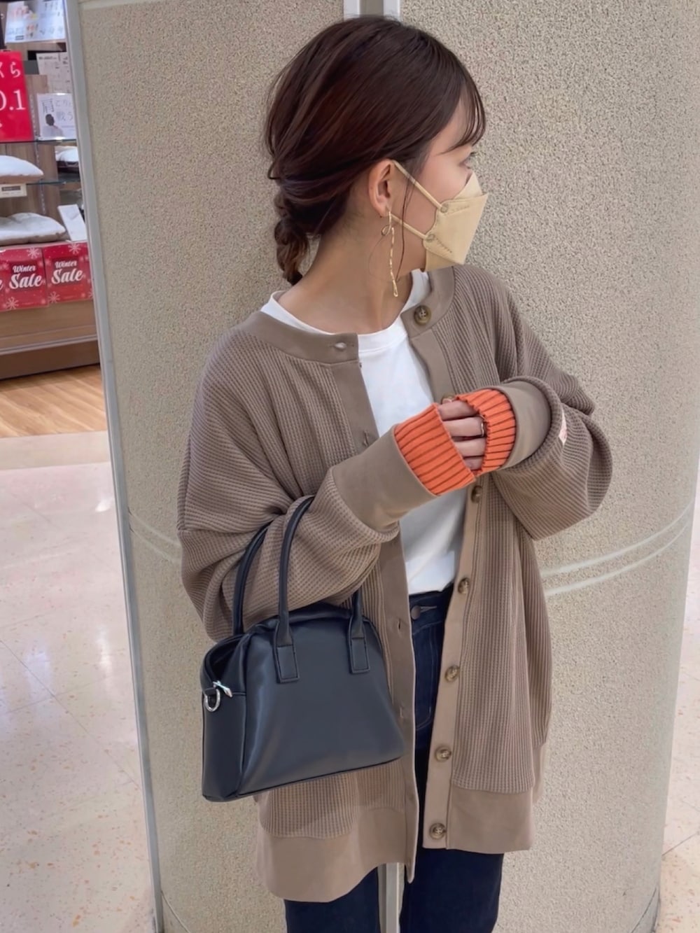 ブラウン系のカーディガン/ボレロ、ブルー系のデニムパンツ、ホワイト系のスニーカーを着用したレディースの春コーディネートの5枚目の写真