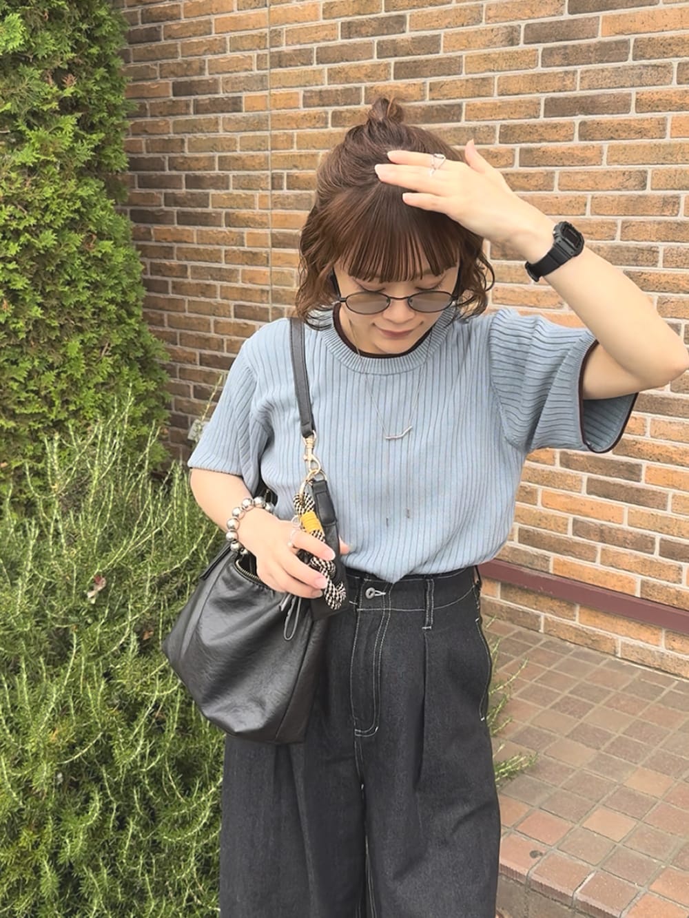 ブルー系のニット/セーター、ブラック系のパンツ、ブラック系のバッグを着用したレディースの秋コーディネートの3枚目の写真