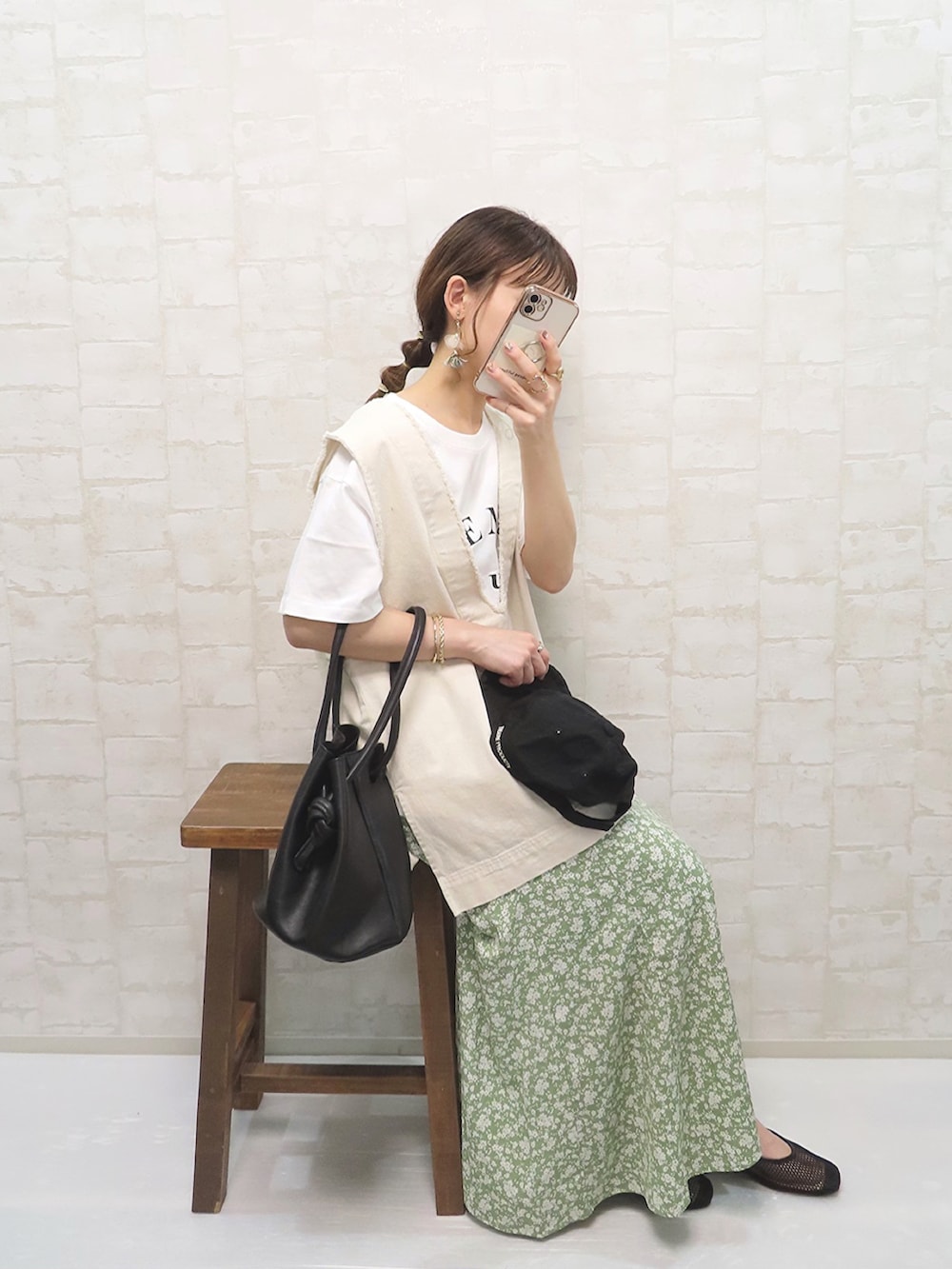 グリーン系のスカート、ホワイト系のTシャツ/カットソー、ホワイト系のベストを着用したレディースの春コーディネートの3枚目の写真