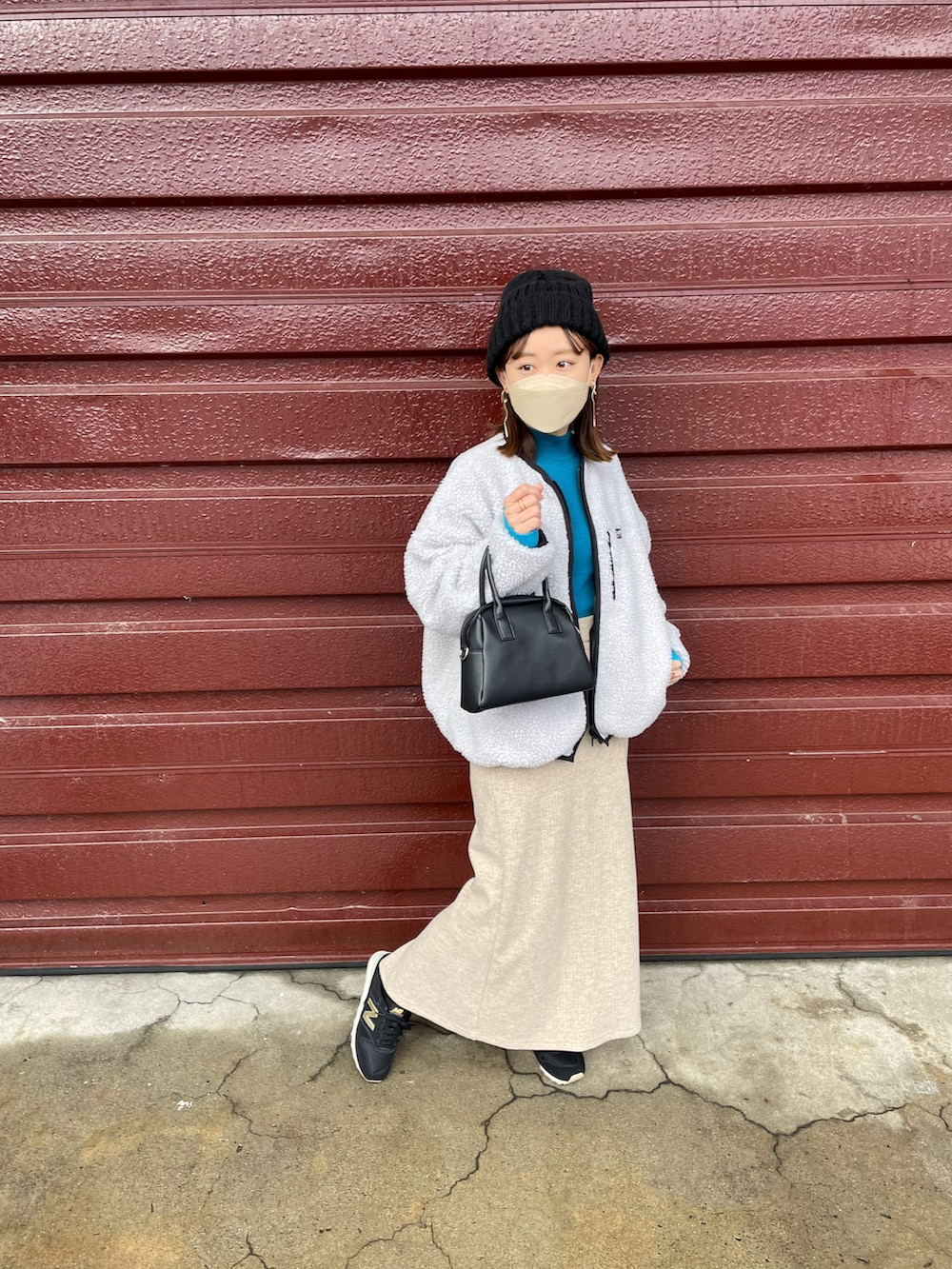 ベージュ系のブルゾン、ブルー系のニット/セーター、ベージュ系のスカートを着用したレディースの冬コーディネートの4枚目の写真